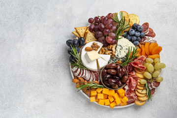 Appetizers boards with assorted cheese, meat, grape and nuts.
