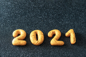 2021 Gingerbread Date. Homemade cookies in the form of numbers 2021 on a black background, Top view, flat lay, copy space. Christmas decoration food background