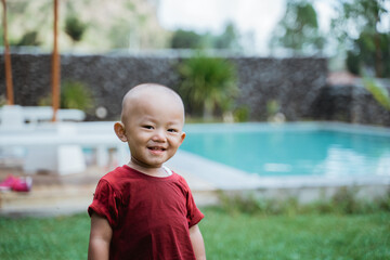 Portrait happy little boy picture in a swimming pool background