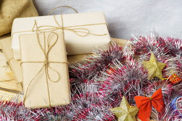Close-up of gifts and sparkling Christmas decorations on a wooden background.