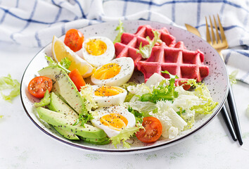 Breakfast with beetroot waffles, boiled egg, tomato and slice avocado on white background. Appetizers, snack, brunch. Healthy food.