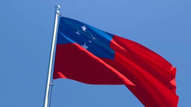 The national flag of Samoa flutters in the wind against a blue sky