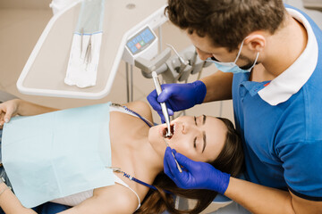 Dentist checking patient's teeth with instruments