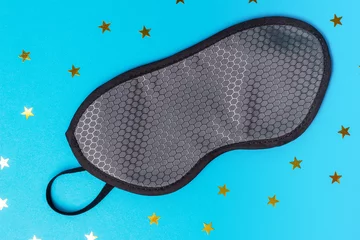 Rollo Grey sleep mask on blue background with stars , top view © TATIANA