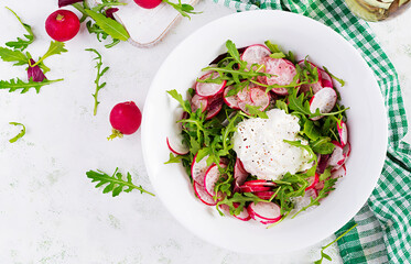 Vegetarian vegetable salad of radish and arugula with sour cream. Healthy vegan food. Top view, overhead, copy space