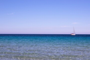 evocative image of the sea of many colors and boats in the background

