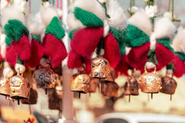 Copper bells with sheep wool bows in colors of Bulgarian flag. Traditional Bulgarian souvenirs Martenitsa on street fair. Handmade decorations for holidays - Christmas and Spring Day. Selective focus