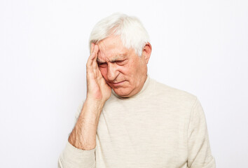 lifestyle, health and people concept: Senior man has headache, on white background