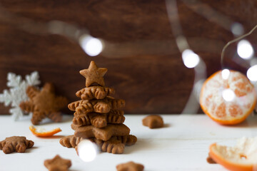 Christmas  tree made of gingerbread cookies, bokeh lights,tangerine,   snowflakes, festive decoration new year or Christmas background