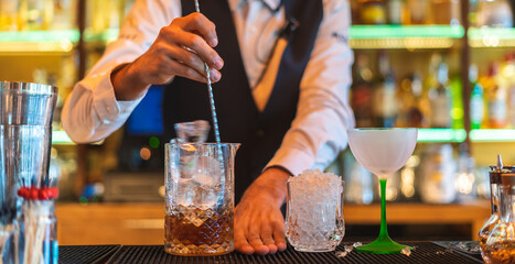 Barman making cocktail at night club