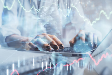 Double exposure of woman hands typing on computer and forex chart hologram drawing. Stock market invest concept.