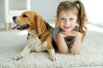 Little girl with a dog at home. High quality photo.