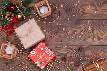 Christmas or new year background, composition of christmas decorations and fir branches, gifts wrapped in paper, candles, flat lay, empty space for greeting text.