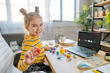 Girl using laptop to study online planets of Solar system