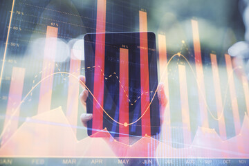 Double exposure of forex chart sketch hologram and woman holding and using a mobile device. Financial market concept.