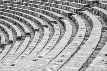 Amphitheater in Coslada. Side view highlighting the geometry of the curved line of the construction, with the stairs to descend on the diagonal of the image. Black and white