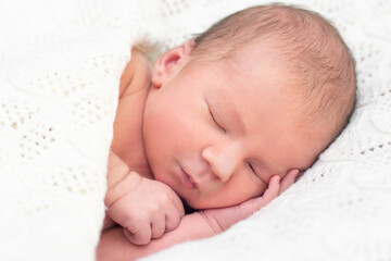 newborn baby sleeps and smiles.