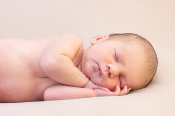 newborn baby sleeps and smiles.