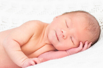 Fototapeta na wymiar newborn baby sleeps and smiles.