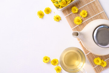 Organic Chrysanthemum flower tea in a cup and teapot on white background, Healthy Herbal drink, Top...
