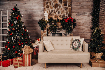 A room with wooden walls, a stone fireplace, a sofa with pillows, a Christmas tree and gifts. New Year's interior in a rural style.
