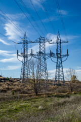 Three high voltage electrical towers on the outskirts of the city.