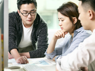 team of three asian business men and woman meeting in office