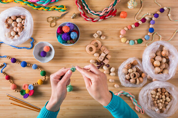 Hobby, crafting, creativity, time at home. Hands making baby beads