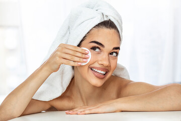 Skin care woman removing face makeup with cotton swab pad - skin care concept. Facial closeup of beautiful model with perfect skin. Girl isolated on white background