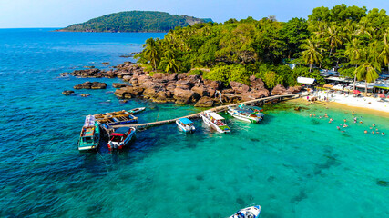 Aerial view of beautiful landscape, tourism boats, and people swimming on the sea and beach on May Rut island (a tranquil island with beautiful beach) in Phu Quoc, Kien Giang, Vietnam. © CravenA