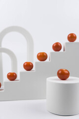 Aesthetic food photography on trendy white podium. Minimal food art still life concept.  Cherry tomatoes on white background.
