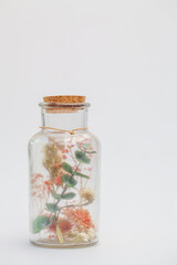 bouquet of dry flowers and potpourri in a glass jar on a white table. High quality photo