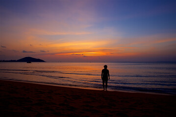 a woman by the sea at sunrise, a beautiful sunset on the island of Koh Samui in Thailand, time for...