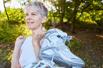 Vital elderly woman with roller skates in nature