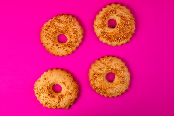 Shortbread cookies sprinkled with slices of hazelnut on a purple background. Delicious homemade cakes made from natural ingredients. Top vew. Space for text.