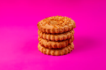 Shortbread cookies sprinkled with slices of hazelnut on a purple background. Delicious homemade cakes made from natural ingredients. Space for text.