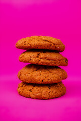 Oatmeal cookies with raisins and nuts inside on a purple background. Delicious homemade cakes made from natural ingredients. Space for text.