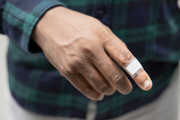 African man having cut wound on his hand, wound dressed by plastic bandage
