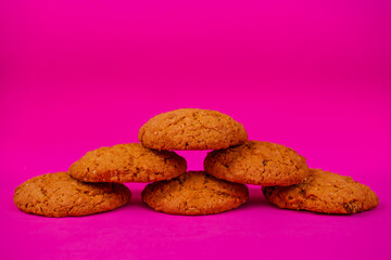 Oatmeal cookies with raisins and nuts inside on a purple background. Delicious homemade cakes made from natural ingredients. Space for text.
