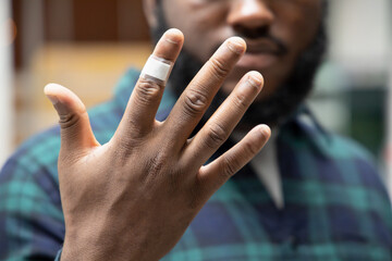 African man having cut wound on his hand, wound dressed by plastic bandage
