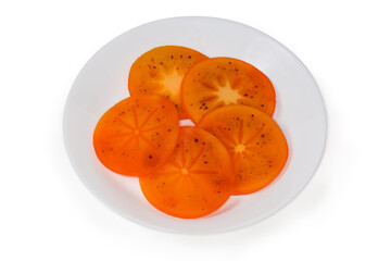 Slices of oriental persimmon cut across on the white dish