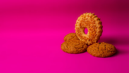 Shortbread cookie sprinkled with slices of hazelnut and oatmeal cookies with raisins and nuts inside on a purple background. Delicious homemade cakes made from natural ingredients