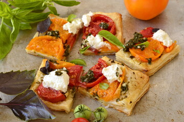 Puff pastry tomato tart with cottage cheese, pesto and basil