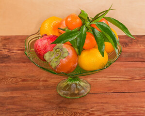 Different fruits in vintage glass fruit vase on rustic table