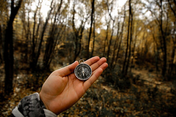 the compass in my hand in the forest
