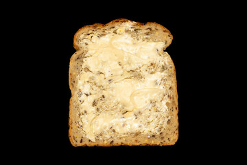 Wholemeal sliced bread and butter which has breakfast health benefits cut out and isolated on a black background, close up studio shot stock photo image