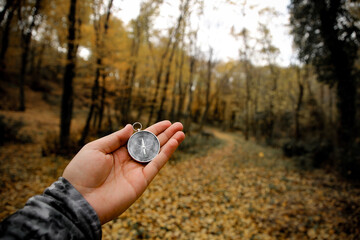 the compass in my hand in the forest
