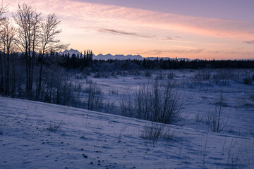 Jarvis Creek in Alaska in winter sunset. Frozen water stream covered by snow