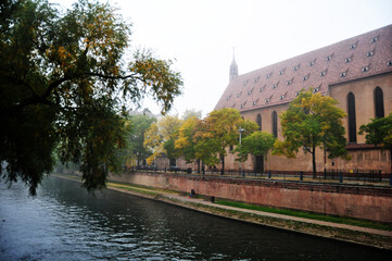 Fototapeta na wymiar View landscape cityscape with Ill river in the Petite France quarter of Strasbourg for French people and travelers foreign travel visit relax with mist in morning time in Grand Est region of France