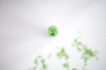 Green stars glitter in glass sphere on isolated white background